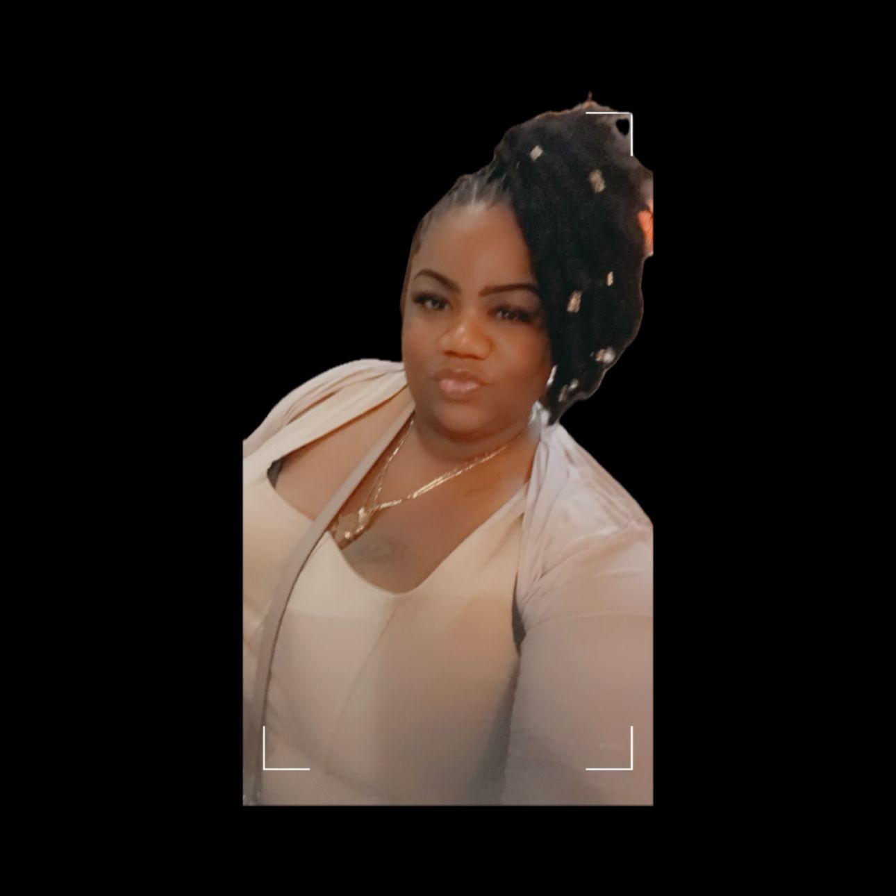 Woman with styled hair and white outfit posing for a photo against a black background.